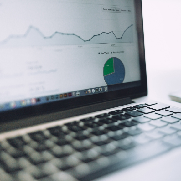 A laptop showing tax insurance statistics and graphs