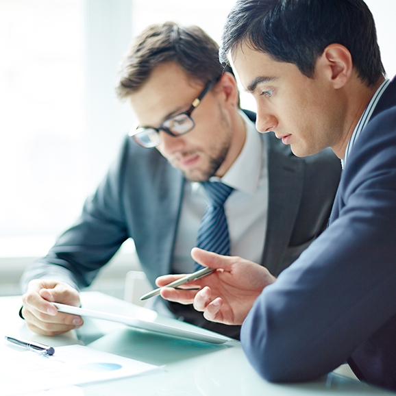 Two tax insurance business men are looking at a tablet together